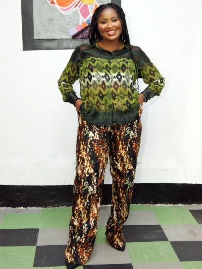 Woman in green diamond print shirt and earth-toned wide-leg trousers, Afrocentric fashion style
